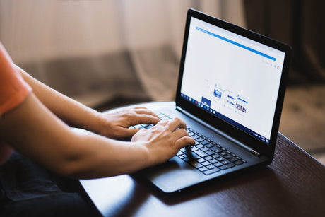 A person using a laptop to type