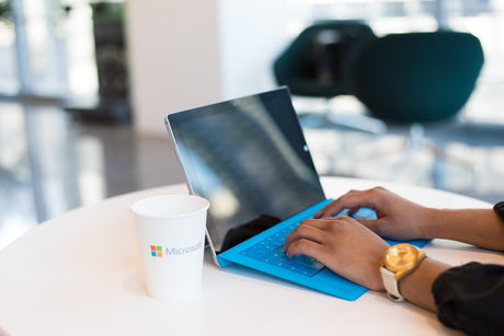 A person using a laptop to compare Microsoft Office vs. 365