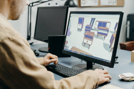 A man using design software on a computer in an office environment
