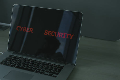A laptop with the word “cybersecurity” displayed on its monitor