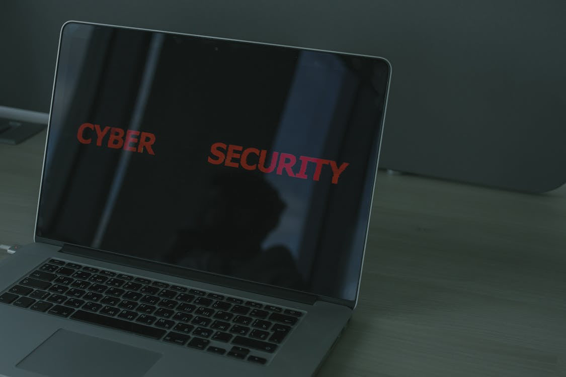 A laptop with the word “cybersecurity” displayed on its monitor