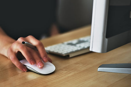 A person’s hand on a mouse as they use office productivity tools