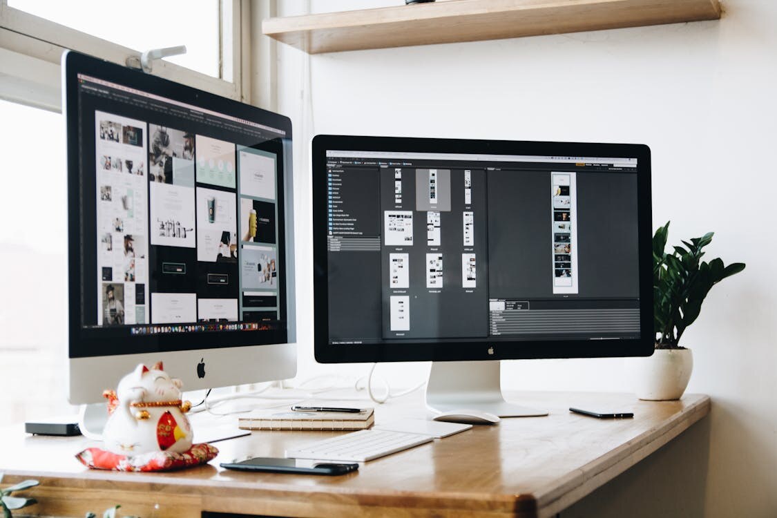 A dual-monitor setup running software that graphic designers use